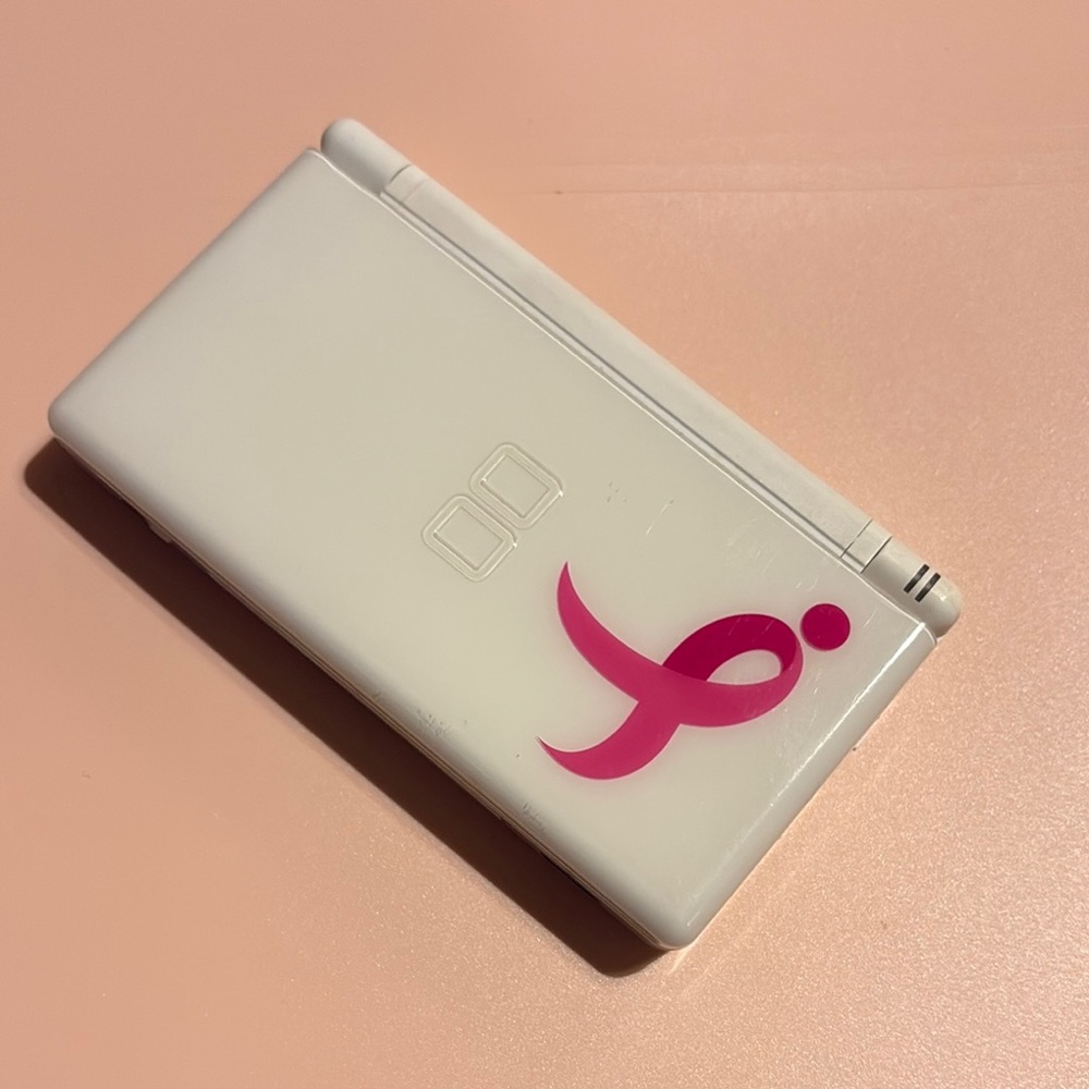 White Handheld Gaming Console with Pink Ribbon